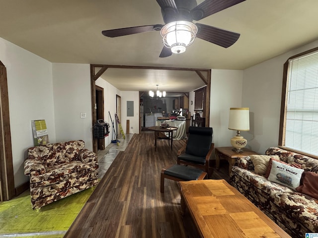 living area featuring arched walkways, wood finished floors, ceiling fan with notable chandelier, and electric panel