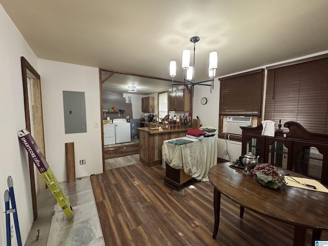 dining room featuring electric panel, wood finished floors, cooling unit, an inviting chandelier, and washer and dryer
