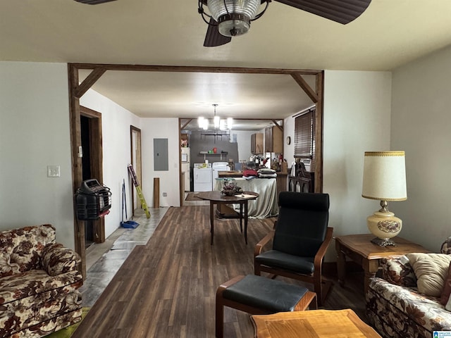 living area featuring separate washer and dryer, an inviting chandelier, wood finished floors, and electric panel