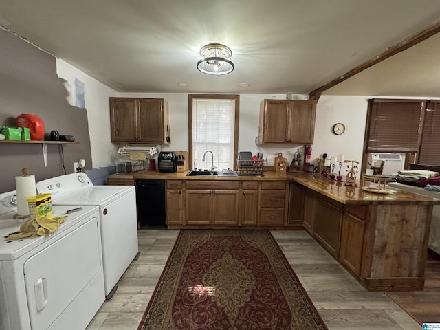 kitchen with a sink, light wood finished floors, dishwasher, a peninsula, and washer and clothes dryer