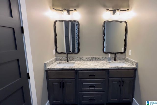 bathroom featuring double vanity, baseboards, and a sink