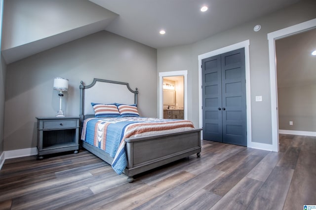 bedroom featuring ensuite bath, recessed lighting, baseboards, wood finished floors, and lofted ceiling