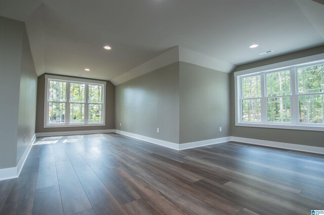 unfurnished room featuring visible vents, dark wood finished floors, baseboards, lofted ceiling, and recessed lighting