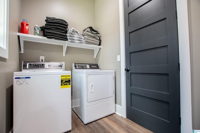 laundry area featuring laundry area, wood finished floors, and washing machine and clothes dryer