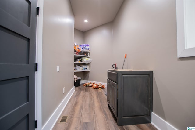 interior space with baseboards, recessed lighting, wood finished floors, and visible vents
