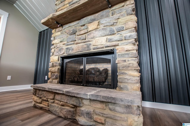 room details with baseboards, wood finished floors, and a fireplace