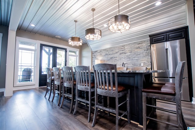 bar with a notable chandelier, hanging light fixtures, french doors, recessed lighting, and wood finished floors