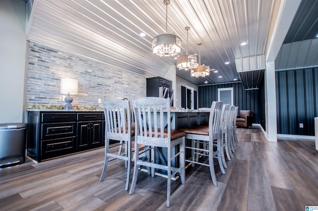 dining room featuring brick wall, an inviting chandelier, wooden ceiling, and wood finished floors