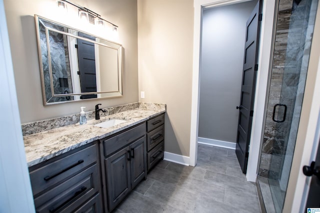 bathroom with vanity, baseboards, tile patterned floors, and a shower stall