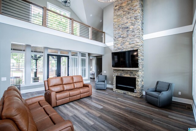 living room with french doors, plenty of natural light, a fireplace, and high vaulted ceiling