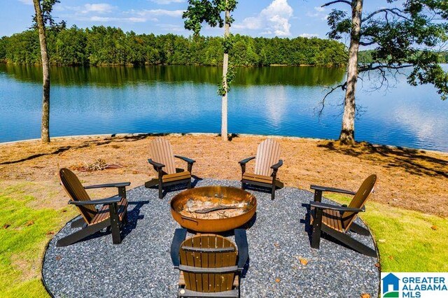 view of water feature featuring an outdoor fire pit and a wooded view