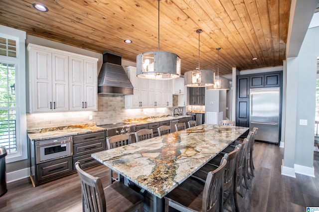 kitchen with wall chimney range hood, wood ceiling, backsplash, stainless steel appliances, and recessed lighting