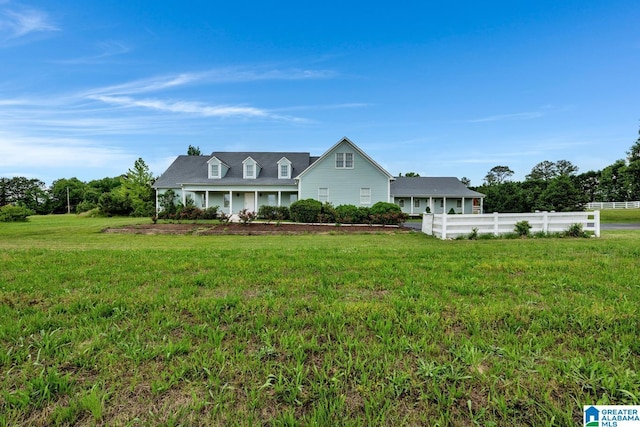 cape cod home featuring fence and a front lawn
