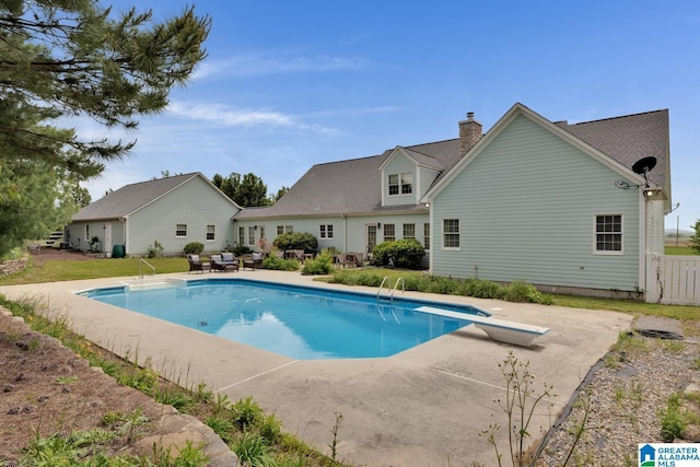 pool with a patio and a diving board