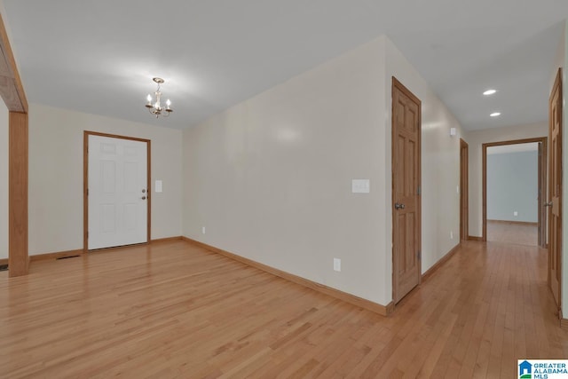 foyer entrance with recessed lighting, baseboards, light wood-type flooring, and a notable chandelier