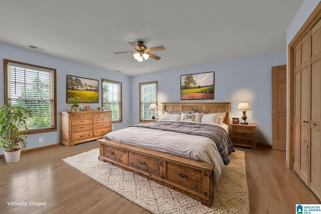 bedroom with light wood-style floors, baseboards, multiple windows, and visible vents