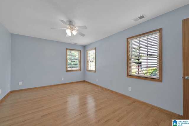unfurnished room with ceiling fan, visible vents, baseboards, and light wood-style floors