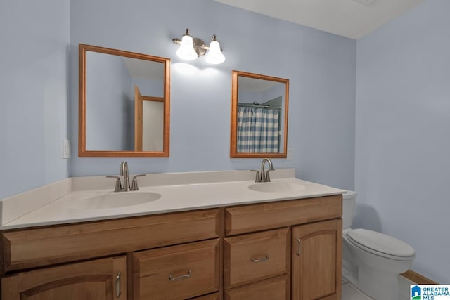 full bathroom with double vanity, toilet, and a sink