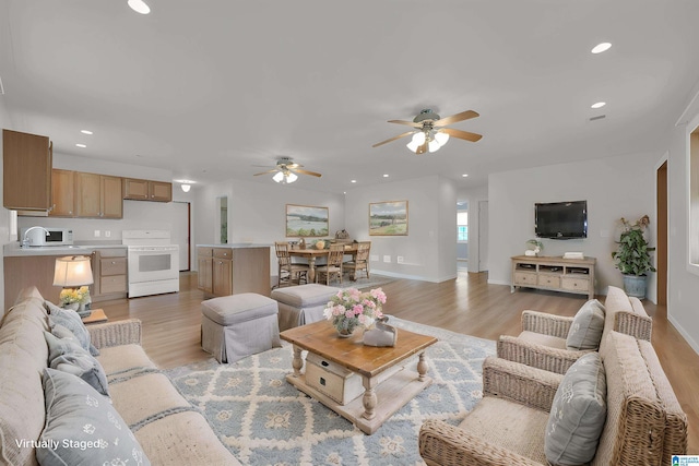 living area with recessed lighting, baseboards, a ceiling fan, and light wood-type flooring