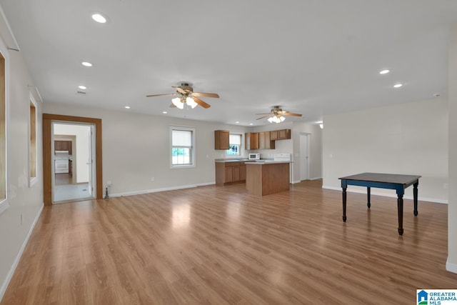 unfurnished living room with recessed lighting, ceiling fan, baseboards, and light wood finished floors