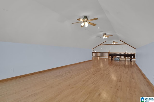additional living space with a ceiling fan, baseboards, vaulted ceiling, and light wood-style flooring
