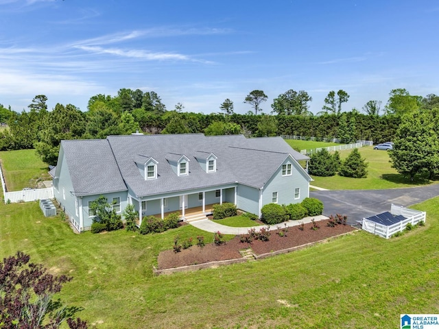 view of front of home with a porch, fence, roof with shingles, and a front lawn