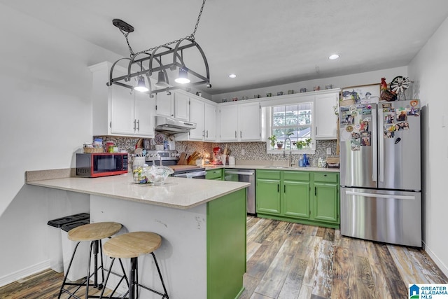 1522 Bower Dr SE, Cullman, AL 35055 - kitchen featuring decorative backsplash, appliances with stainless steel finishes, a sink, a peninsula, and under cabinet range hood