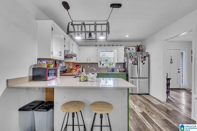 1522 Bower Dr SE, Cullman, AL 35055 - kitchen featuring white cabinets, appliances with stainless steel finishes, light countertops, a peninsula, and under cabinet range hood