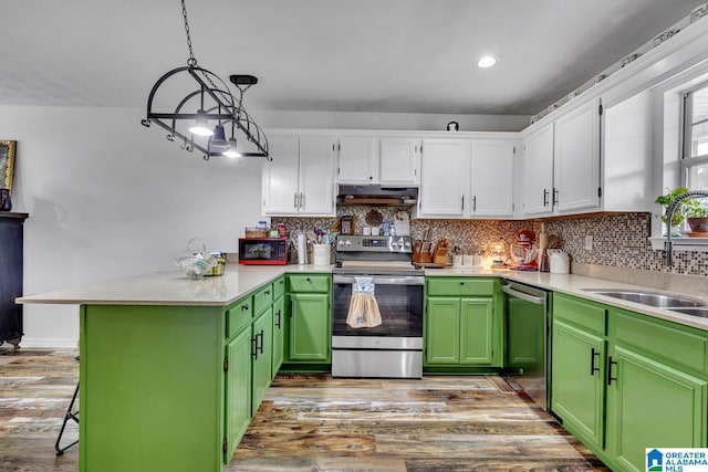 1522 Bower Dr SE, Cullman, AL 35055 - kitchen with stainless steel appliances, white cabinetry, a peninsula, wood finished floors, and under cabinet range hood