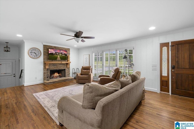 living area featuring baseboards, ceiling fan, ornamental molding, and wood finished floors