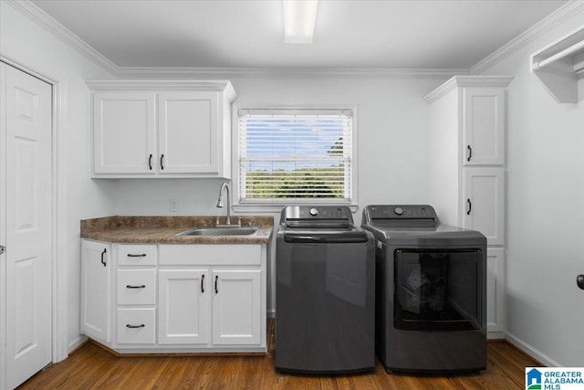 clothes washing area featuring washer and dryer, dark wood-style flooring, cabinet space, a sink, and ornamental molding