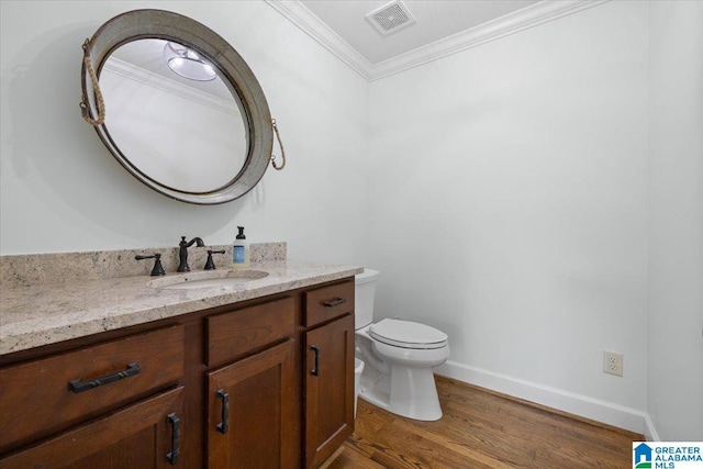 bathroom featuring visible vents, crown molding, vanity, wood finished floors, and toilet