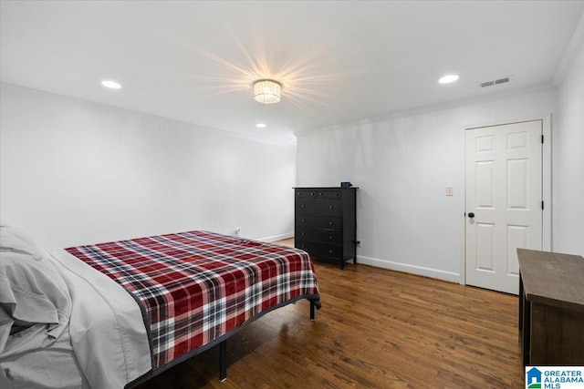 bedroom featuring visible vents, ornamental molding, wood finished floors, baseboards, and recessed lighting