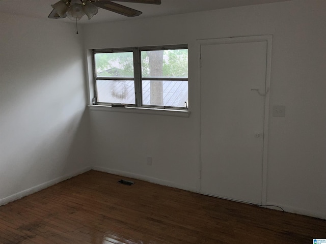 unfurnished room with visible vents, a ceiling fan, baseboards, and wood finished floors