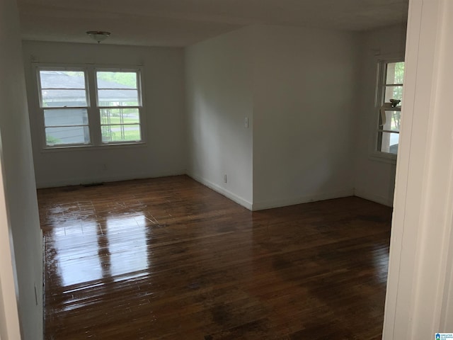 spare room featuring visible vents, baseboards, and hardwood / wood-style floors