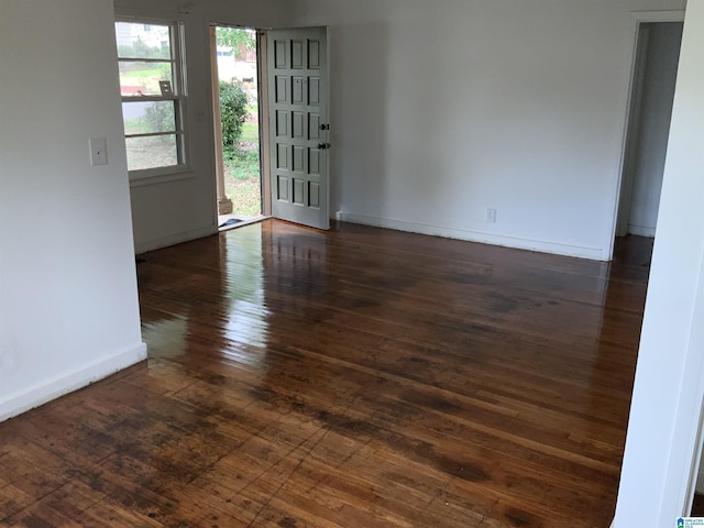 empty room with baseboards and hardwood / wood-style flooring