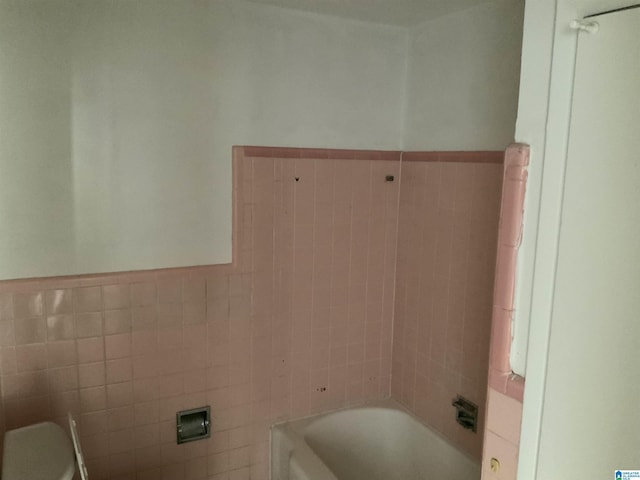 full bath featuring shower / bath combination, wainscoting, and tile walls