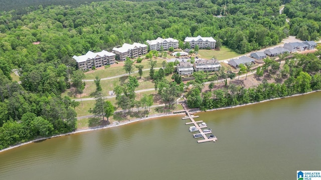 aerial view of property's location with a forest, a large body of water, and apartment complex