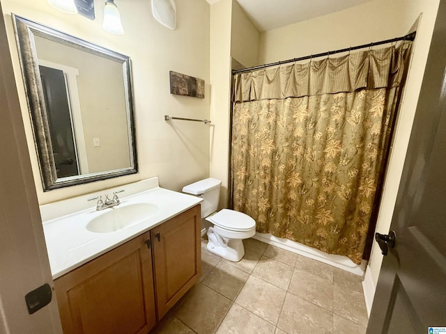 bathroom with toilet, vanity, and tile patterned flooring