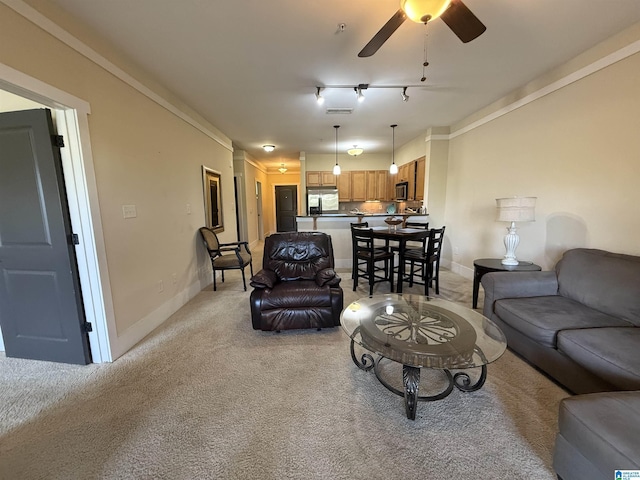 living area featuring light colored carpet, baseboards, ceiling fan, and ornamental molding