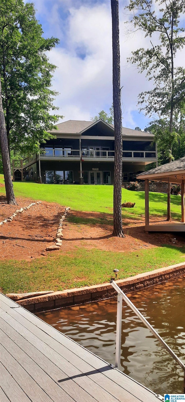 rear view of property featuring a water view and a yard