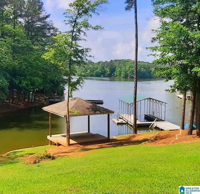 view of dock featuring a water view, a yard, and a wooded view