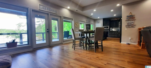 dining room with recessed lighting, baseboards, and light wood-style flooring