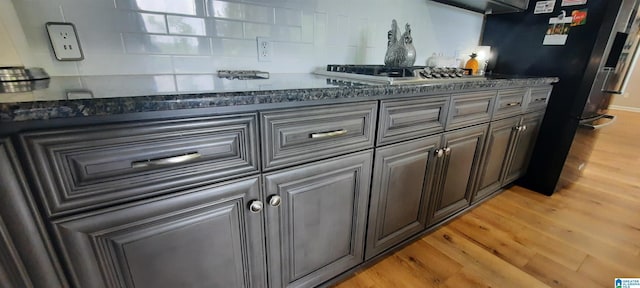 kitchen with light wood-style floors, stainless steel gas cooktop, and freestanding refrigerator