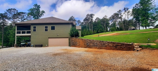 view of home's exterior featuring an attached garage, a yard, driveway, and cooling unit