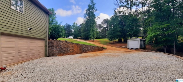 view of yard featuring an outbuilding, a shed, and gravel driveway