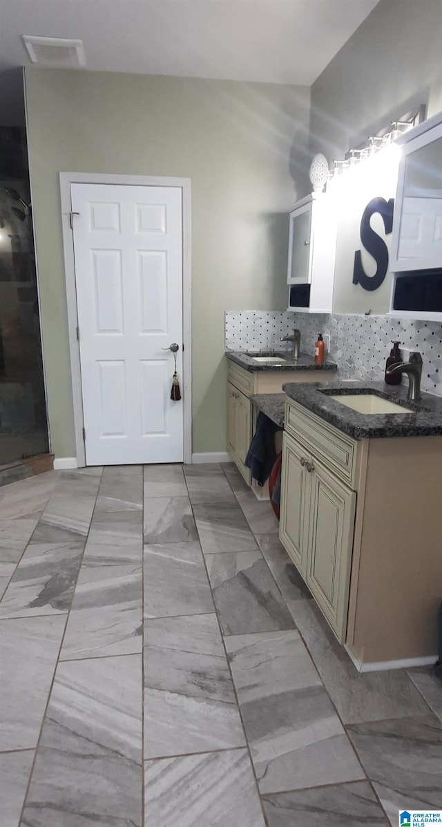 full bathroom featuring a walk in shower, vanity, marble finish floor, baseboards, and decorative backsplash