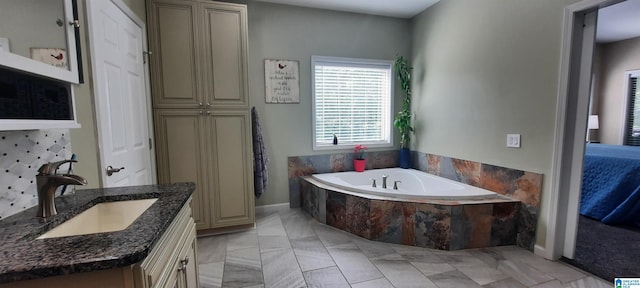 bathroom with vanity, baseboards, and a bath