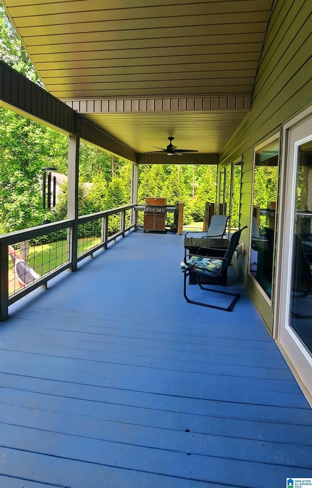 wooden terrace with ceiling fan and a grill