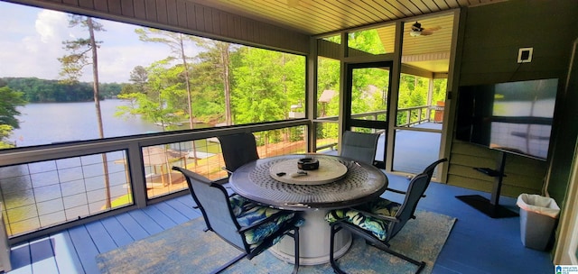 sunroom with a water view, ceiling fan, outdoor dining space, and a wealth of natural light